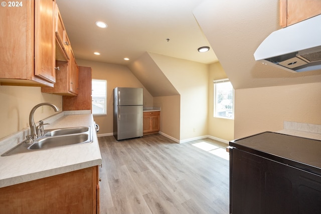 kitchen featuring appliances with stainless steel finishes, light hardwood / wood-style floors, and sink