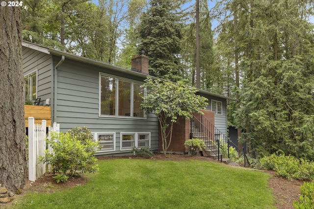 rear view of house featuring a yard