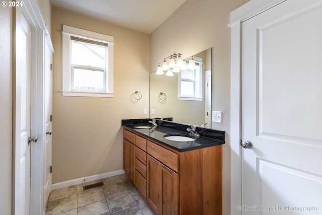 bathroom featuring vanity, a healthy amount of sunlight, and tile patterned floors