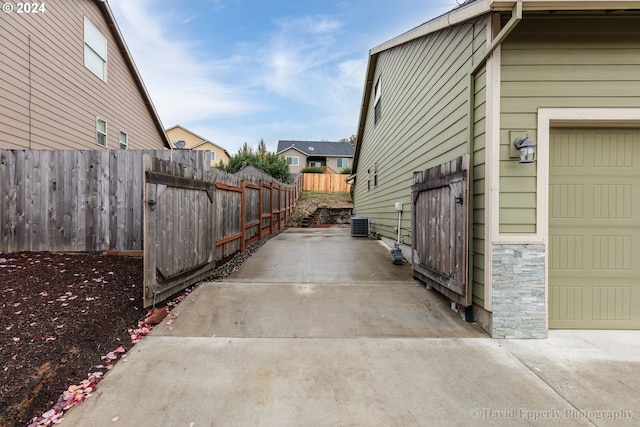 view of property exterior featuring central air condition unit and a garage