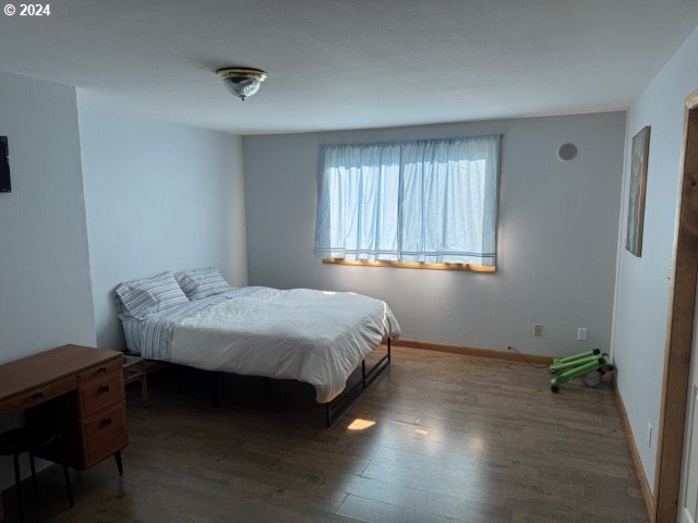 bedroom with dark wood-type flooring