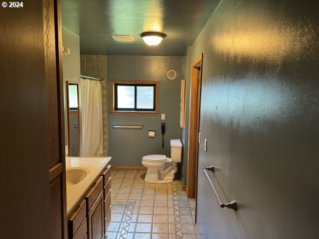 bathroom featuring a shower with curtain, tile patterned floors, vanity, and toilet