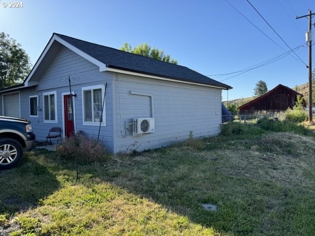 view of side of property featuring a yard and ac unit