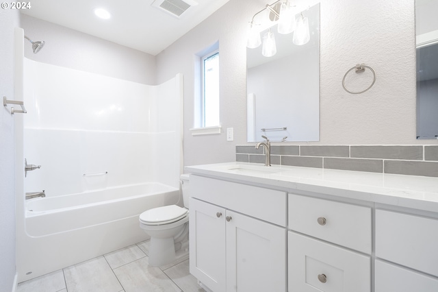 full bathroom featuring tile patterned floors, shower / bath combination, toilet, decorative backsplash, and vanity