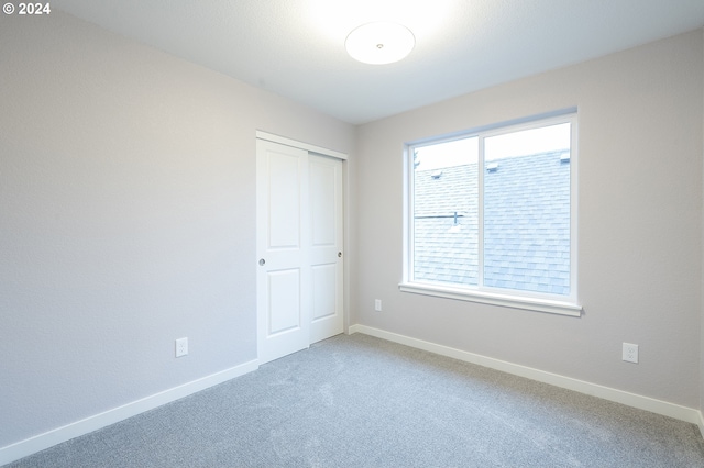 unfurnished bedroom with carpet and a closet