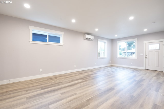 interior space with light hardwood / wood-style floors and a wall unit AC