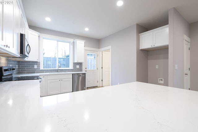 kitchen featuring dishwasher, decorative backsplash, white cabinets, and sink