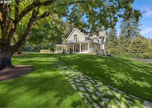 country-style home featuring a porch and a front lawn