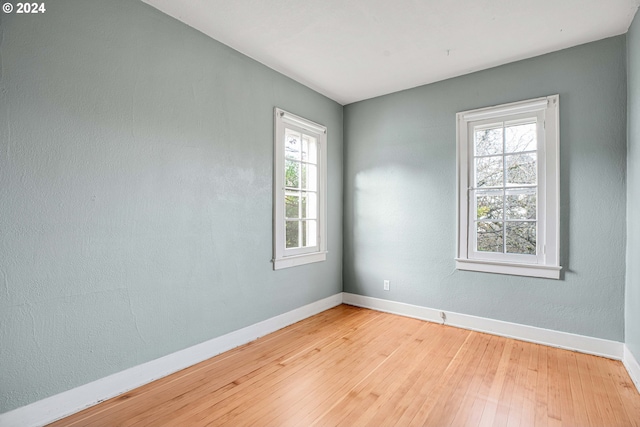 unfurnished room featuring hardwood / wood-style floors and plenty of natural light