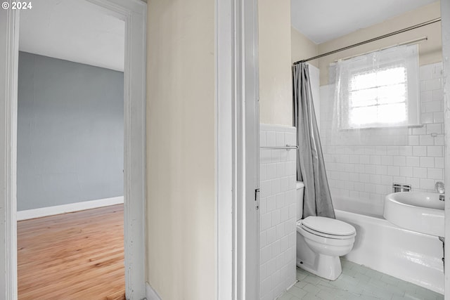 bathroom featuring shower / tub combo with curtain, hardwood / wood-style floors, tile walls, and toilet