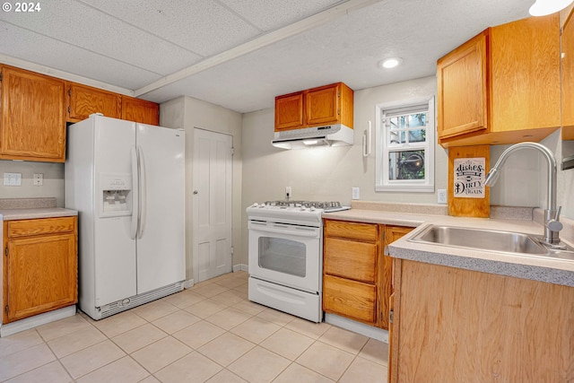 1175 Hines St SE, Salem, OR 97302 - kitchen with white appliances, under cabinet range hood, a sink, light countertops, and light tile patterned floors
