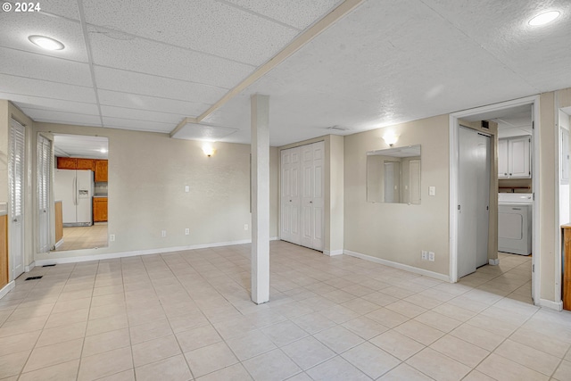 1175 Hines St SE, Salem, OR 97302 - finished basement with washer / dryer, white fridge with ice dispenser, baseboards, and light tile patterned flooring