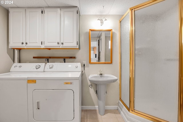 laundry area featuring light tile patterned flooring, sink, and washing machine and clothes dryer