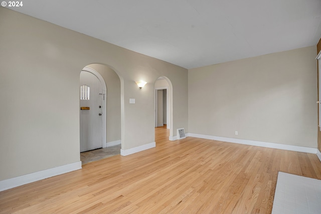 1175 Hines St SE, Salem, OR 97302 - spare room featuring arched walkways, light wood-type flooring, and baseboards