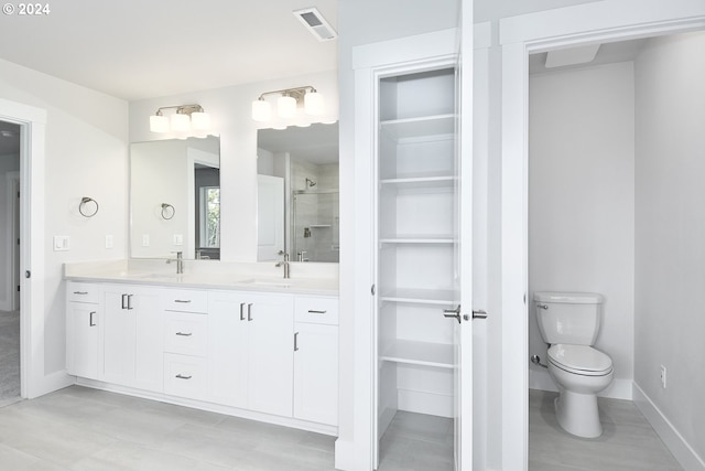 bathroom featuring tiled shower, vanity, and toilet