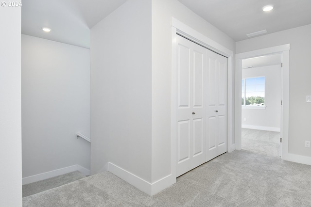 hallway with light colored carpet