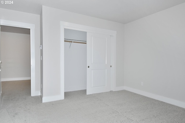 unfurnished bedroom featuring carpet flooring and a closet