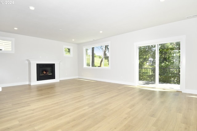 unfurnished living room with light hardwood / wood-style flooring and plenty of natural light