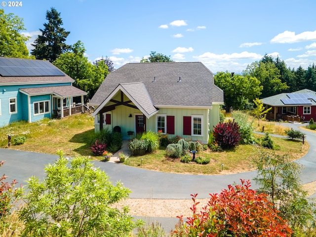 view of front of home featuring a front lawn and solar panels