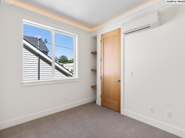 unfurnished bedroom featuring light carpet and a wall mounted AC