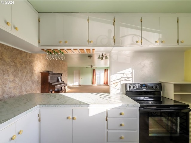 kitchen featuring black / electric stove, white cabinetry, and kitchen peninsula