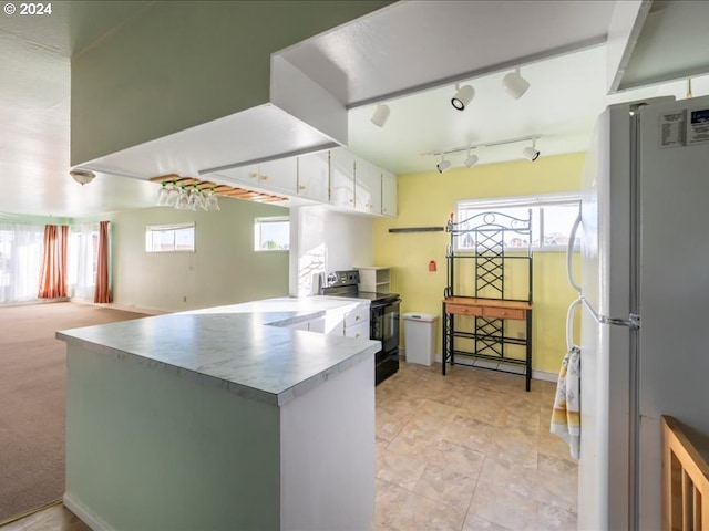 kitchen featuring white cabinetry, black electric range oven, kitchen peninsula, white fridge, and light carpet