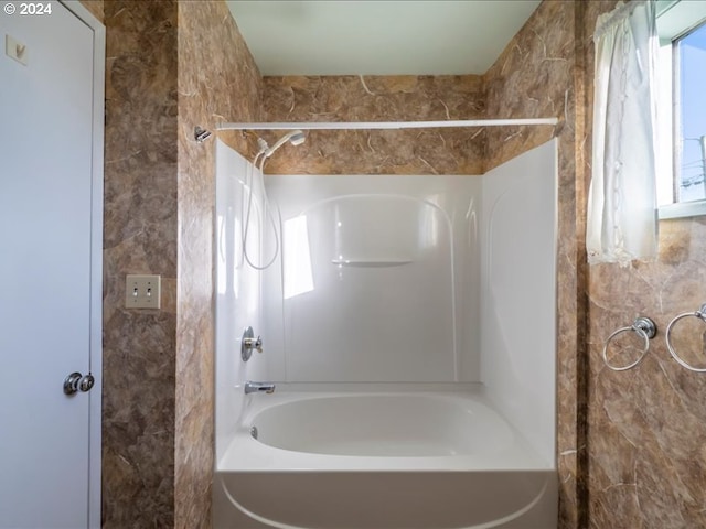 bathroom featuring plenty of natural light and bathing tub / shower combination