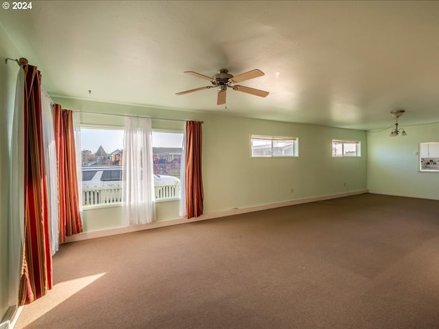 carpeted spare room featuring ceiling fan and a healthy amount of sunlight