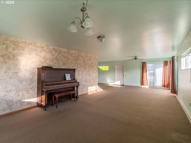 misc room with carpet floors and ceiling fan with notable chandelier