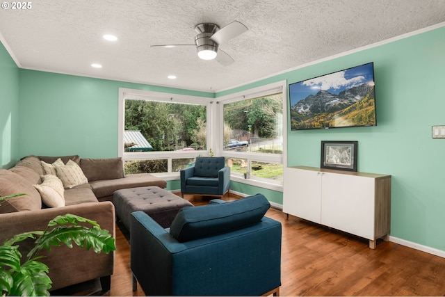 living room featuring ceiling fan, hardwood / wood-style floors, crown molding, and a textured ceiling