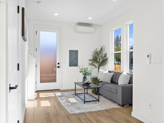 2519 NE Killingsworth St Unit 1, Portland, OR 97211 - living room featuring a wall mounted air conditioner, wood finished floors, electric panel, baseboards, and recessed lighting