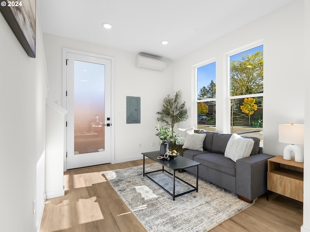 2519 NE Killingsworth St Unit 1, Portland, OR 97211 - living room with an AC wall unit, wood finished floors, electric panel, recessed lighting, and baseboards