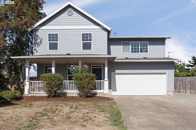view of front of house with an attached garage, fence, covered porch, and driveway