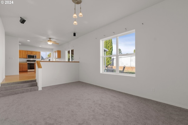 unfurnished living room with ceiling fan and light colored carpet