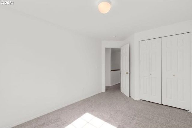 unfurnished bedroom featuring carpet floors and a closet