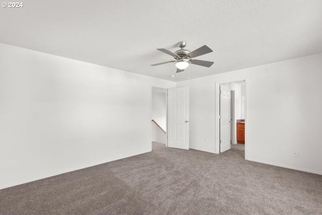 carpeted spare room featuring ceiling fan