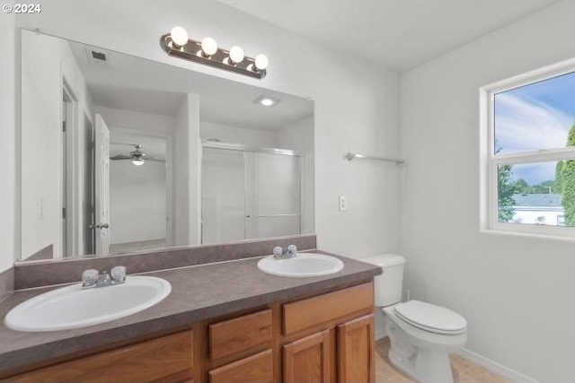 bathroom featuring ceiling fan, vanity, toilet, and an enclosed shower