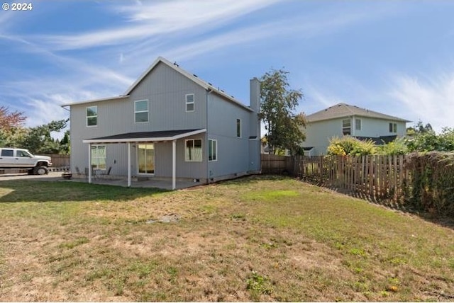 rear view of house with a yard and a patio