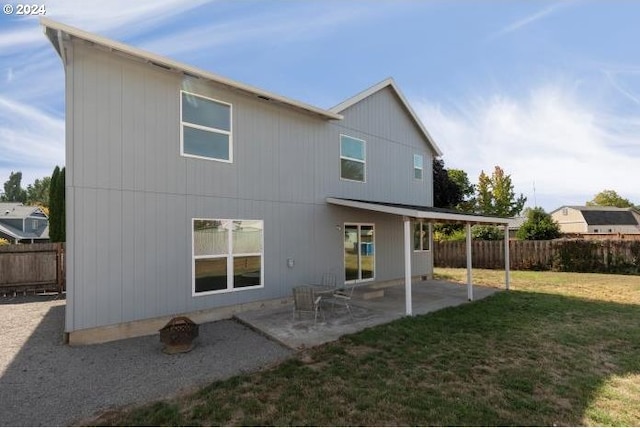 back of property with a lawn, a fenced backyard, and a patio area