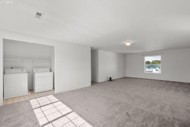 interior space with washer and dryer and light colored carpet