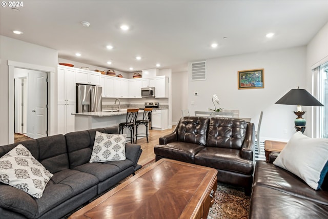 living room featuring light hardwood / wood-style floors and sink