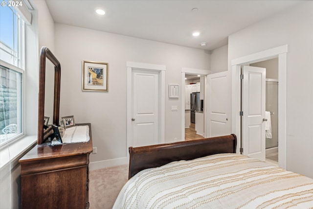 bedroom featuring stainless steel fridge and light carpet