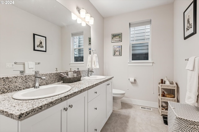 bathroom with tile patterned flooring, vanity, and toilet