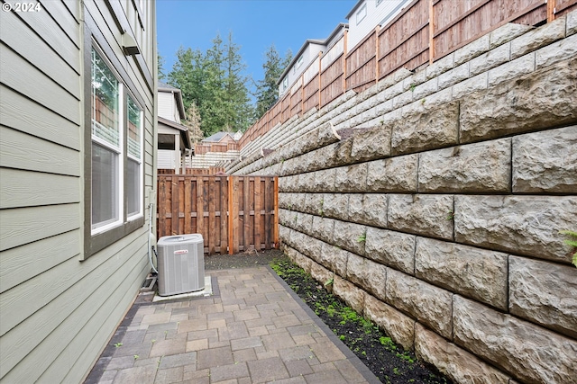 view of side of property with central AC unit and a patio