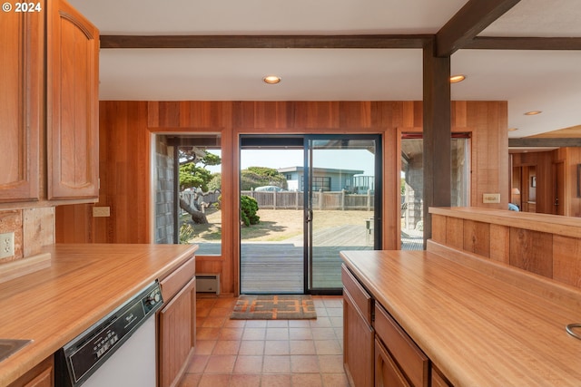 kitchen featuring wood walls, dishwasher, and beam ceiling