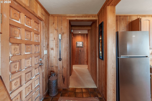 hall with dark tile patterned floors and wood walls