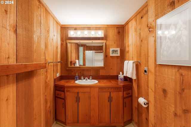 bathroom with vanity and wood walls