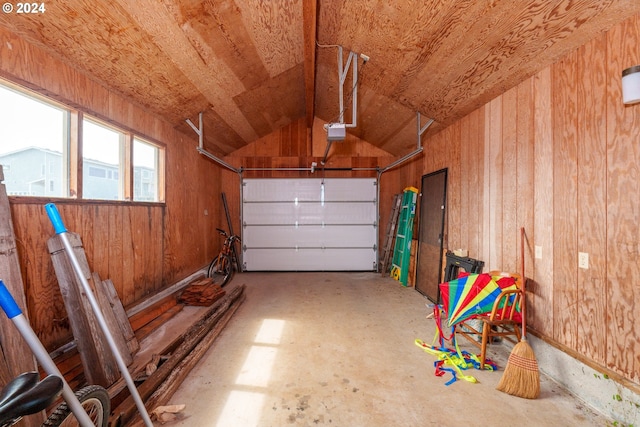 garage featuring a garage door opener and wooden walls