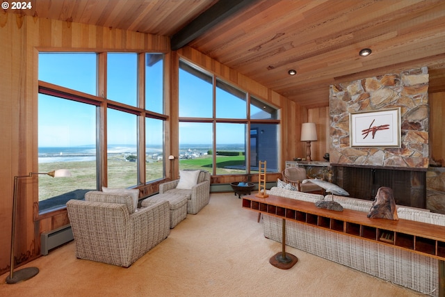 carpeted living room featuring vaulted ceiling with beams, wooden ceiling, a water view, a baseboard radiator, and a fireplace