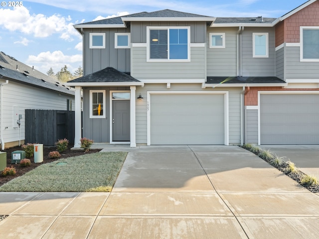 multi unit property featuring a shingled roof, an attached garage, board and batten siding, fence, and driveway